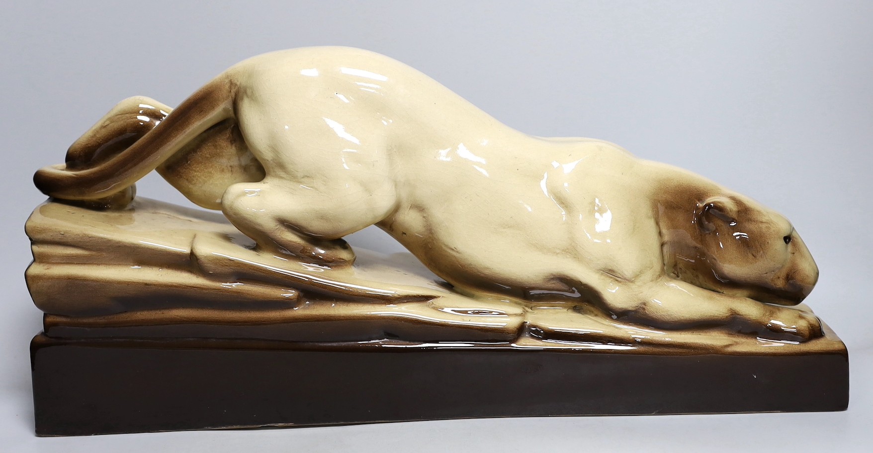 An Art Deco French pottery figure of a stalking panther, 53cm long